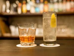 dos vasos de bebidas sentados en una mesa en 癒楽 伊豆大島, en Oshima