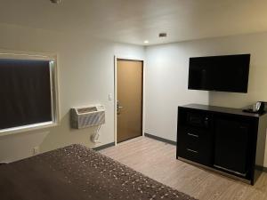 a bedroom with a bed and a flat screen tv at 112 Motel in Medford