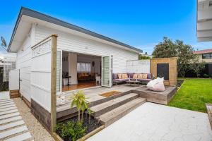 a backyard with a house with a patio at Waterfront Sunsets Studio in Ngunguru