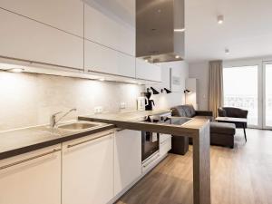 eine Küche mit weißen Schränken und ein Wohnzimmer in der Unterkunft 6 Personen Ferienhaus in Wendtorf in Wendtorf