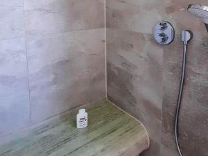 eine Dusche mit einer Flasche Seife auf einer Holzbank in der Unterkunft 6 Personen Ferienhaus in Wendtorf in Wendtorf + 50 Fotos