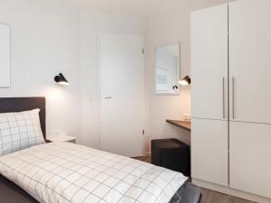 ein weißes Schlafzimmer mit einem Bett und einem Schrank in der Unterkunft 6 Personen Ferienhaus in Wendtorf in Wendtorf