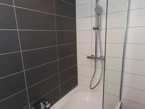 a shower in a bathroom with black and white tiles at Charmant Appartement Rénové · Séjour avec WiFi · Accès Direct aux Pistes · Val-d'Isère - FR-1-518-124 in Val dʼIsère