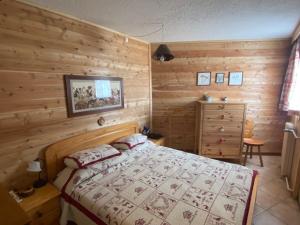 um quarto com uma cama e uma parede de madeira em Appartement Montgenèvre, 3 pièces, 6 personnes - FR-1-445-183 em Montgenèvre