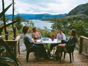 a group of people sitting around a table on a deck at Seven-Bedroom Holiday home in Flatanger 2 in Straum