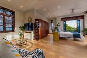 une chambre avec un lit, un canapé et une table dans l'établissement Sông River Homestay Hội An, à Hội An