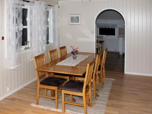 Holiday home Selsøyvik في Håkaringen: غرفة طعام مع طاولة وكراسي خشبية