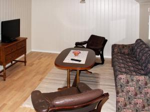 ein Wohnzimmer mit einem Tisch und einem Sofa in der Unterkunft Holiday home Selsøyvik in Håkaringen