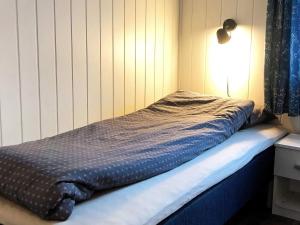 a small bed in a room with a lamp at 6 person holiday home in Dyrvik in Dyrvik