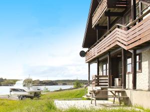 Holiday home Selsøyvik في Håkaringen: منزل به قارب متوقف بجوار مبنى
