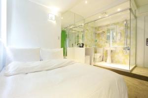 um quarto com uma grande cama branca e um chuveiro em Forever Inn em Taipei