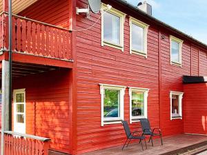 una casa roja con 2 sillas en una terraza en 9 person holiday home in KORTGARDEN, 