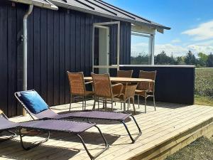 een houten terras met een tafel en stoelen erop bij 5 person holiday home in R m in Kongsmark