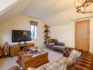 a living room with a couch and a tv at Treetops - Uk38735 in Barlow