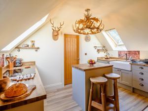 a kitchen with a chandelier and a table with bread on it at Treetops - Uk38735 in Barlow