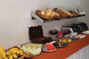 a table with a bunch of bread and baskets of food at Espigão Palace Hotel in Resende