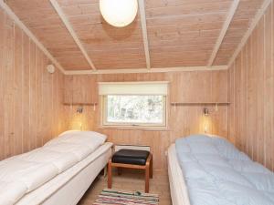 2 camas en una habitación con paredes de madera y ventana en Three-Bedroom Holiday home in Humble 2 en Humble