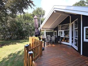 Casa con terraza de madera con sombrilla en Three-Bedroom Holiday home in Humble 2 en Humble