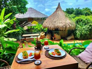 a table with two plates of food and drinks on it at Terra Sancta Resort in El Nido
