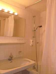 y baño con lavabo y ducha con espejo. en Hotel Sonne Lienz en Lienz