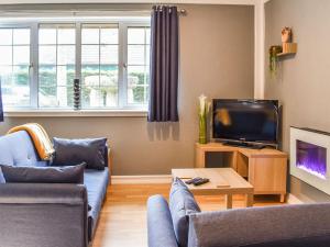 a living room with a couch and a tv at Rabbits Warren in Trelaske