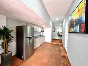 a large kitchen with a stainless steel refrigerator at 4br LUXURY ROOFTOP oldcity AC jacuzzi hottub wifi in Cartagena de Indias