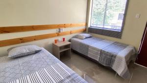 a bedroom with two beds and a window at La Posada de Pepe in Piura