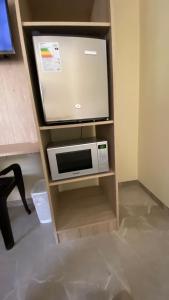 a tv sitting on a stand with a microwave at La Posada de Pepe in Piura +11 photos