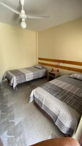 a bedroom with two beds and a ceiling fan at La Posada de Pepe in Piura