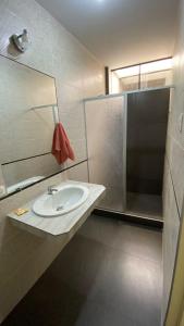 een badkamer met een wastafel, een spiegel en een douche bij La Posada de Pepe in Piura