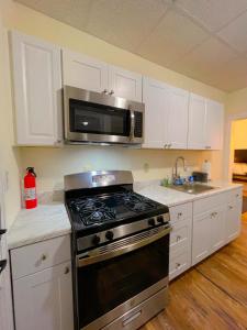 a kitchen with a stove and a microwave at Home sweet home in the heart of Wilmington. in Wilmington