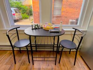 a small table with two chairs and a window at Home sweet home in the heart of Wilmington. in Wilmington