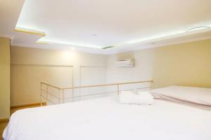 a bedroom with two white beds in a room at Urbanview Rumah Kandjani Yogyakarta in Yogyakarta