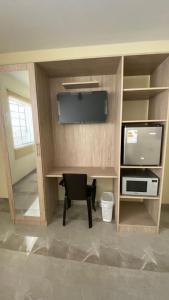 Habitación con escritorio, silla y TV. en La Posada de Pepe, en Piura