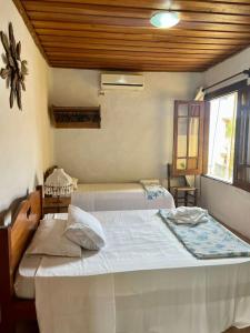 a bedroom with two beds and a window at Pousada Refugium in Itacaré