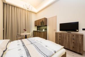 a bedroom with a bed and a flat screen tv at Ostrovni Astra Apartment in Prague