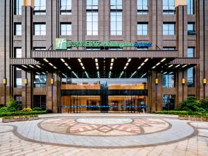 Holiday Inn Express Nanning Jiangnan, an IHG Hotel في نانينغ: مبنى امامه ساعه