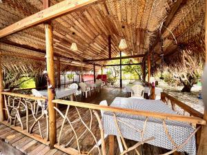 a patio with tables and chairs in a straw building at Va'a i te Moana in Avatoru