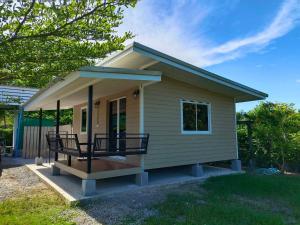 a small tiny house with a porch and a porch at บ้านในสวนรีสอร์ทBannnaisuan Resort in Prachuap Khiri Khan