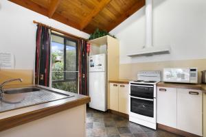 a kitchen with white appliances and a sink at Deppelers - Lakes Entrance Retreat in Lakes Entrance +3 photos