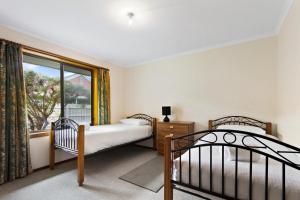 a bedroom with two beds and a window at Deppelers in Lakes Entrance