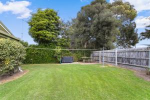 a yard with a fence and a volleyball hoop at Deppelers in Lakes Entrance