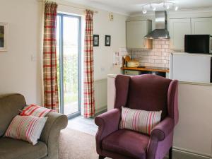 a living room with a couch and a chair at Willows Barn in Clenchwarton