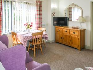 a living room with a table and a tv at Willows Barn in Clenchwarton