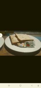 a sandwich on a white plate on a table at BUKIT GARDEN in Mataram