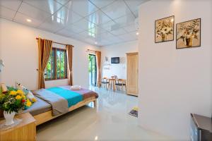 a bedroom with a bed and a dining room at Alley Garden Homestay Hoi An in Hoi An