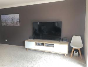 a flat screen tv sitting on top of a white cabinet at Renas Court, Unit 6, 72 Little Street in Forster