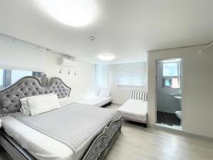 a bedroom with a large bed and a bathroom at W Premium Guesthouse Incheon airport in Incheon