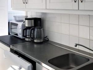 a kitchen counter with a sink and a microwave at 10 person holiday home in S LEN in Stöten