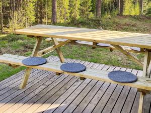 a picnic table with four seats on a wooden deck at 10 person holiday home in SÄLEN in Stöten